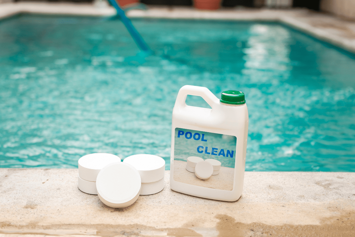chlorine pool cleaner container on pool edge-min