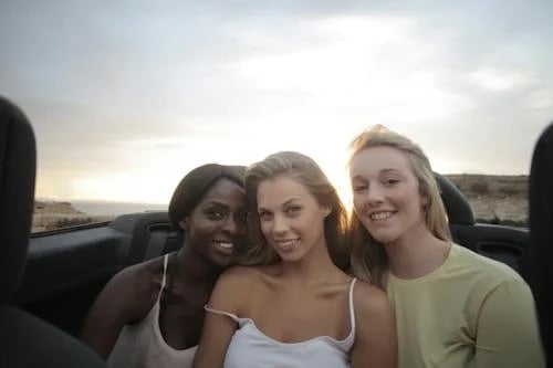 three-young-women-smiling-at-sunset