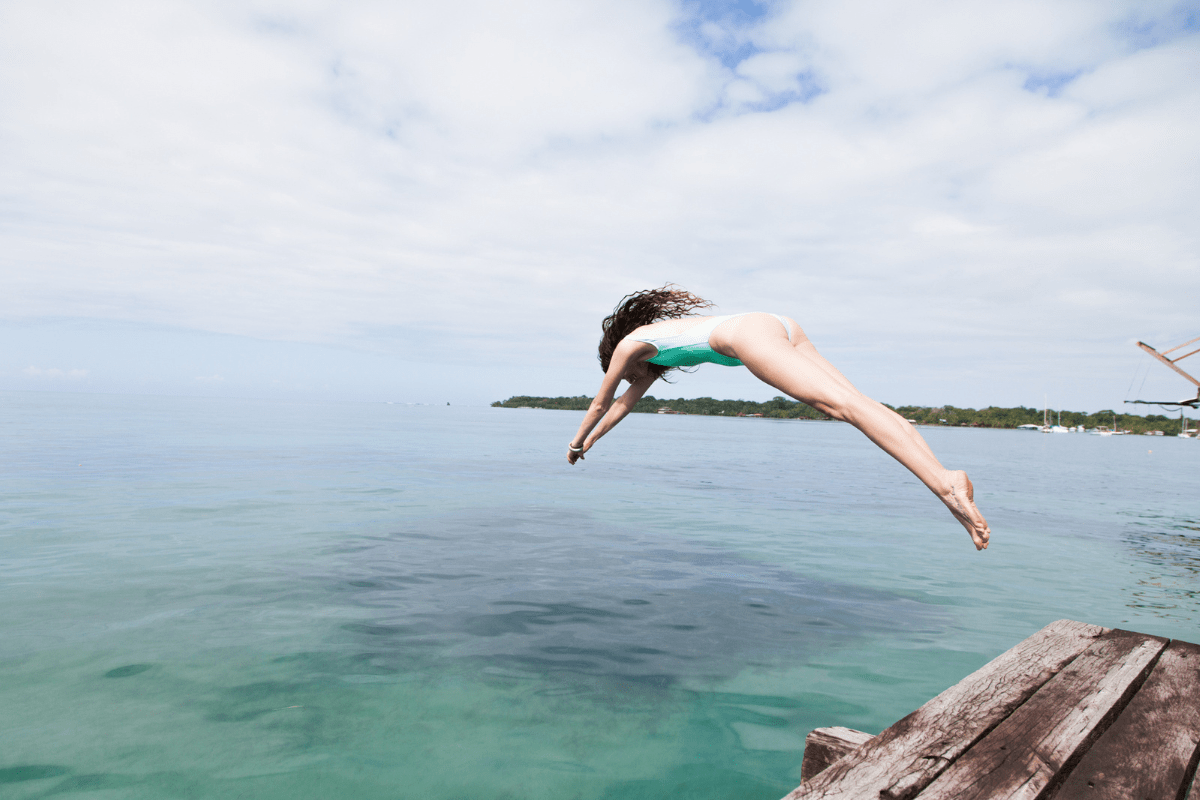 woman diving into warm ocean-min