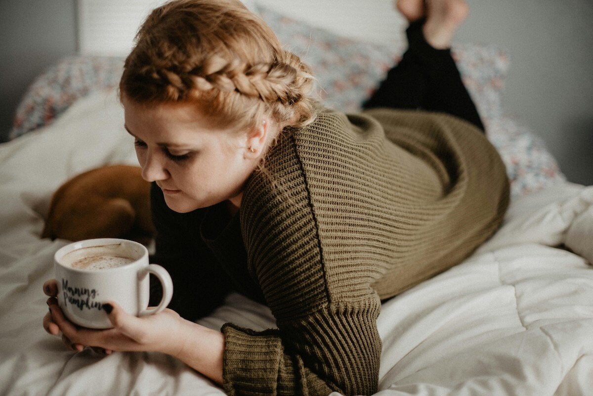 woman-in-sweater-lying-on-bed