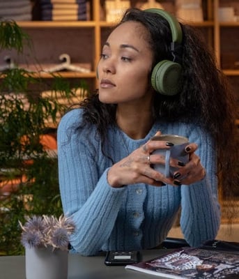 woman-listening-to-music-headphones-pensive-min